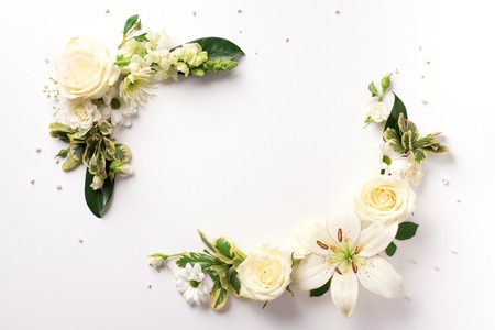 White roses, lily, gerbera over light background. Flat lay, top view. Creative layout. Spring or summer banner with copy space. Flowers compositionの写真素材