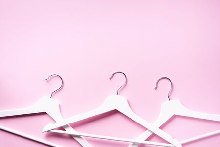 White clothes hangers on pink background with copy space. Flat lay. Top view.の写真素材