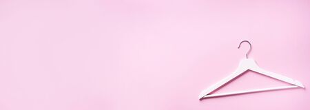 White clothes hangers on pink background with copy space. Flat lay. Top view.の写真素材