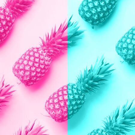 Fresh pineapples on trendy neon pink and blue color background. Top View. Pop art design, creative...