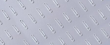 Pattern of white paper clips on grey background. Back to school. Office, business, paperwork,...