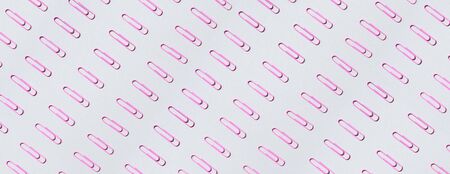 Pink paper clips on pastel grey background. Top view, flat lay. Back to school concept. College,...
