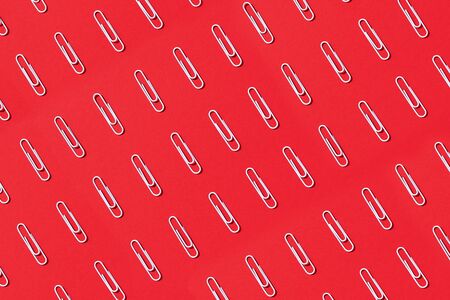 White paper clips on pastel red background. Top view, flat lay. Back to school concept. College, institute education, office work.の写真素材