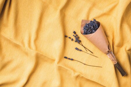 Dry lavender flowers on yellow fabric texture background. top view. Flat lay. Free space for text or advertisement. Autumn harvest concept.の写真素材