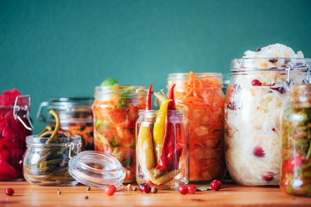 Probiotics food background. Korean carrot, kimchi, beetroot, sauerkraut, pickled cucumbers in glass jars. Winter fermented and canning food concept. Banner with copy space.の写真素材