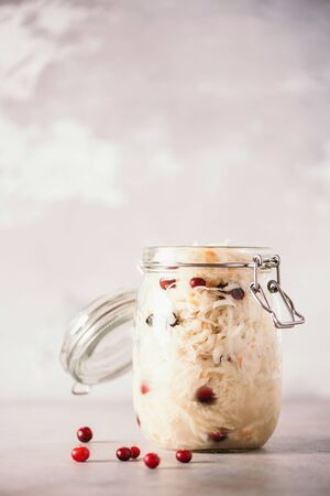 Sauerkraut in glass jar on grey background with copy space. Fermented and marinated cabbage at home. The best natural probiotic food.の写真素材