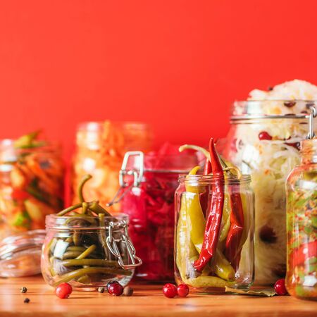 Probiotics food background. Korean carrot, kimchi, beetroot, sauerkraut, pickled cucumbers in glass jars. Winter fermented and canning food concept. Banner with copy space.の写真素材