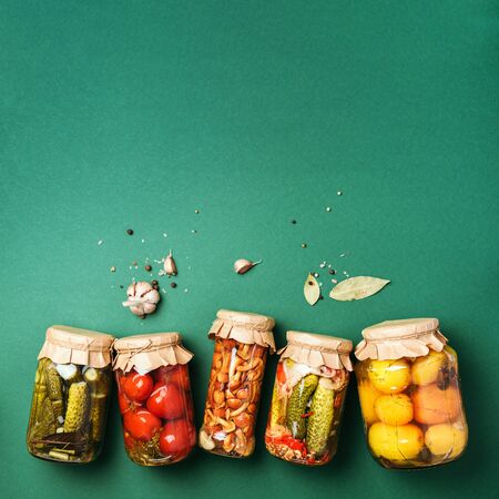 ?ucumber, squash and tomatoes pickling and canning into glass jars. Ingredients for vegetables preserving. Healthy fermented food concept. Top view. Copy spaceの写真素材