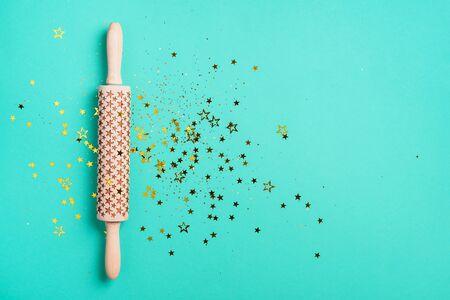 Rolling pin, gold glitter stars on blue background. Top view. Copy space. Christmas baking concept. Holidays composition. Banner for menu, recipe, ingredients.の写真素材