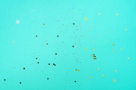 Golden star sparkles on blue background. Christmas and New year concept. Festive backdrop with copy space.の写真素材