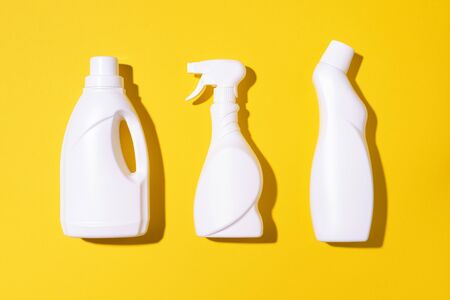 Composition with plastic bottles of cleaning products over yellow background. Top view. Flat lay. Copy space. Plastic waste. Detergent bottle pattern.の写真素材