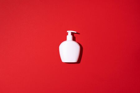 Shampoo and soap bottles on red background. Top view. Flat lay. Copy spaceの写真素材