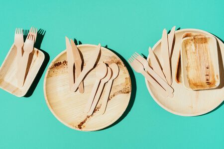 Eco craft paper tableware. Paper cups, bamboo wood dishes and wooden cutlery on blue background....