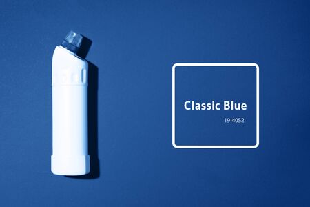 White plastic bottle of cleaning product, household chemicals or liquid laundry detergent on classic blue background. Top view. Flat lay. Copy space. Detergent bottle.の写真素材