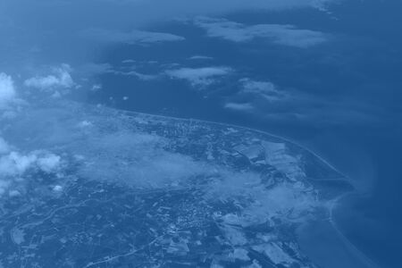 Top view from landing airplane in trendy monochrome blue and calm color background. Window plane...