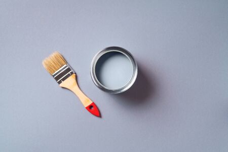 Brush and open paint can with on pastel background. Top view, copy space. Appartment renovation, repair, building and home design concept.の写真素材