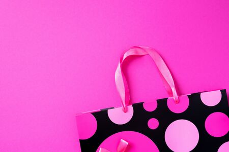 Black friday sale concept. Top view of pink paper shopping bag on trendy bright background. Copy space. Womans day. Valentines day. Ready for birthday party.の写真素材