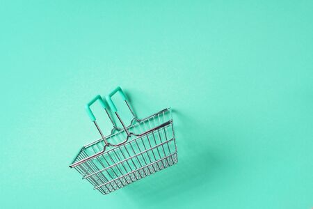 Top view of supermarket shopping basket on trendy green background. Black friday sale concept. Copy space. Sustainable lifestyle.の写真素材