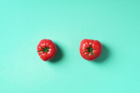 Red tomato on trendy green background with copy space. Top view. Flat lay. Summer minimal concept. Vegan and vegetarian diet.の写真素材