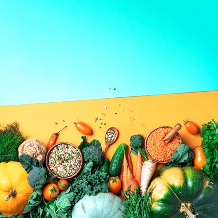 Organic vegetables, lentils, beans, raw ingredients for cooking on trendy yellow and green background. Healthy, clean eating concept. Vegan or gluten free diet. Copy space. Top view. Food frame.の写真素材