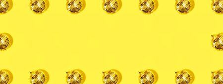 Frame with Christmas gold baubles organized on yellow background. Top view. Flat lay. Creative New...