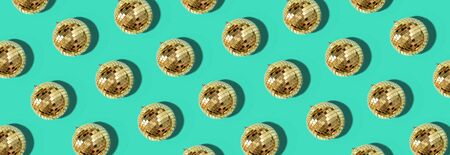 Christmas gold baubles organized on blue background. Top view. Flat lay. Creative New year pattern. Party time concept. Banner.の写真素材