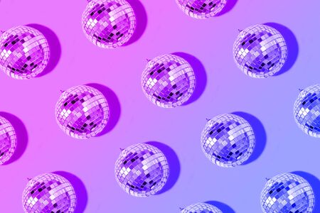 Christmas gold baubles organized on neon background. Top view. Flat lay. Creative New year pattern. Party time concept. Banner.の写真素材