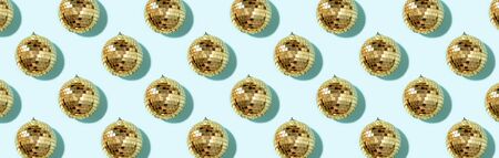 Christmas gold baubles organized on blue background. Top view. Flat lay. Creative New year pattern. Party time concept. Banner.の写真素材