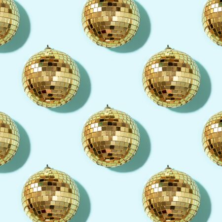 New year baubles. Shiny gold disco balls on blue background. Pop disco style attributes, retro...