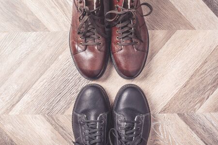 Black and brown colors of shoes on wooden background. Sale and shopping concept. Copy space. Banner....