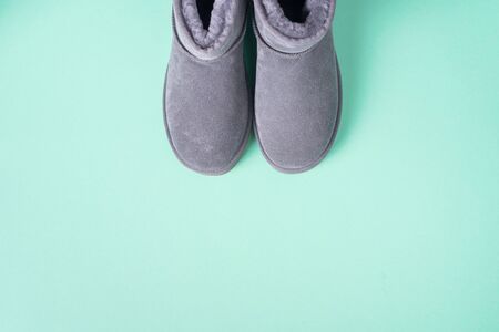 Grey ugg boots on blue background. Winter concept. Christmas and new year holiday. Copy space.の写真素材