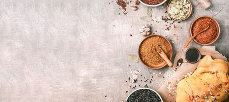Raw chicken marinated with garlic, thyme, spices and lemon on grey concrete background. Top view. Copy space. Baking dish. Cooking ingredients frame with spices and herbs. Banner.の写真素材
