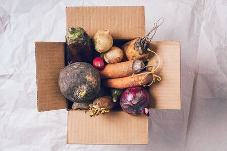 Donation box full of non gmo vegetables on craft paper background. Concept of zero waste production....