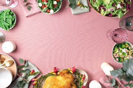 Valentine day, Women's Day, mother's day, wedding brunch, festive family lunch and dinner concept. Festive family dinner table. Serving plates, bowls with salads and vegetables dishes, snack, whole roasted chicken, eucalyptus flowers on pink shabby background.の写真素材