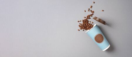 Take away coffee cup and coffee beans on grey background. Top view. Copy space. Minimal composition, layout for design. Coffee conceptの写真素材