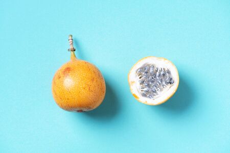 Sweet granadilla or grenadia on blue background. Top view. Copy space. Creative design banner. Summer time. Exotic food, tropical fruit concept.の写真素材