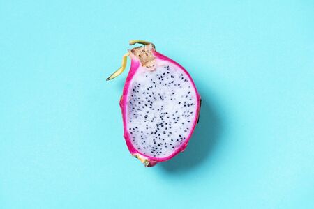 White pitahaya or dragon fruit on blue background. Top view. Copy space. Creative design banner. Summer time. Tropical travel, exotic fruit. Vegan and vegetarian concept.の写真素材