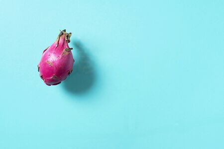 Pink pitahaya or dragon fruit on blue background. Top view. Copy space. Creative design banner. Summer time. Tropical travel, exotic fruit. Vegan and vegetarian concept.の写真素材