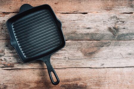 Empty grill iron pan on wooden background. Top view. Copy space. Healthy, clean food and eating concept. Zero waste. Cooking frame.