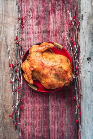 Roasted whole chicken with Christmas decoration on wooden background. Top view, copy space. Healthy diet concept.の写真素材