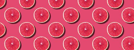 Grapefruit pattern on pink background. Top view. Creative design, minimal flat lay concept. Summer time. Tropical travel, exotic fruit. Vegan and vegetarian food.の写真素材