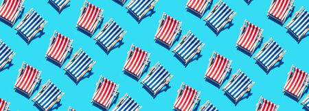 Deck chairs pattern on blue paper background. Flat lay and copy space. Summer travel vacation concept. Creative design, minimal flat lay concept. Minimal composition. Summer time.の写真素材