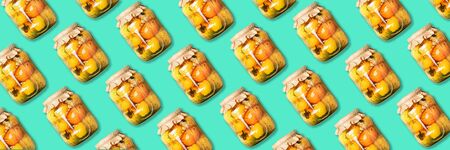 Pickled tomatoes in jar pattern on blue background. Top view. Creative packing design. Canned and preserved vegetables. Ingredients for vegetables preserving. Healthy fermented food conceptの写真素材