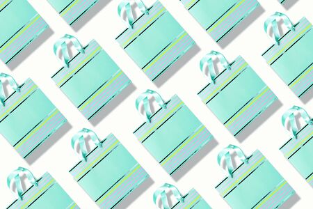 Top view of turquoise paper shopping bag pattern on trendy pink background. Copy space. Creative...