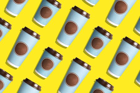 Take away tea or coffee cup on yellow background. Top view. Copy space. Creative design for packaging. Take away food. Minimal composition, layout for design. Coffee concept.の写真素材