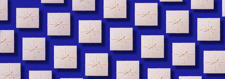 Valentine's Day. Grey gift box pattern on blue background. Top view. Copy space. Creative design for packaging. Festive backdrop for holidays: Birthday, Valentines day, Christmas, New Yearの写真素材
