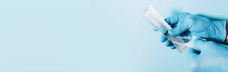 Medical concept banner with copy space. Hand in gloves holding syringe on blue background....