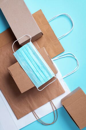 Craft paper cups, food box, gloves, bags, mask on blue background. Top view. Banner, copy space....