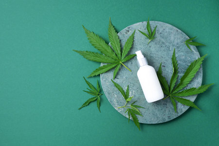 Cosmetic product with CBD oil and hemp leaves on marble background. Flat lay, copy space. Top view. Natural skin care. Cream with hemp oil and marijuana leavesの写真素材