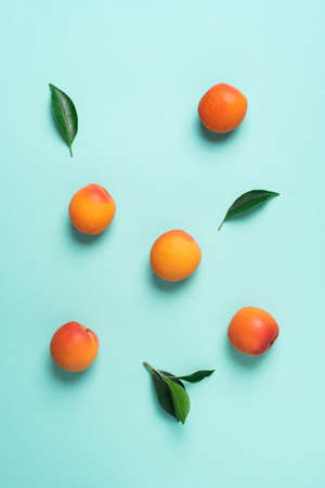 Apricot pattern on blue background. Top view, flat lay. Fresh summer fruit concept. Creative design....